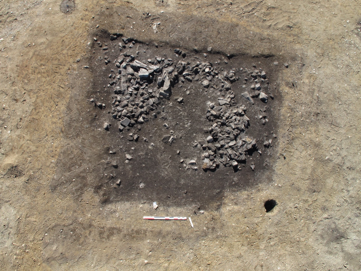 Oversiktsfoto av grophuset etter at 10 cm av det mørkebrune, humusholdige jordlaget er fjernet. Foto: Hanne Bryn, NTNU Vitenskapsmuseet.